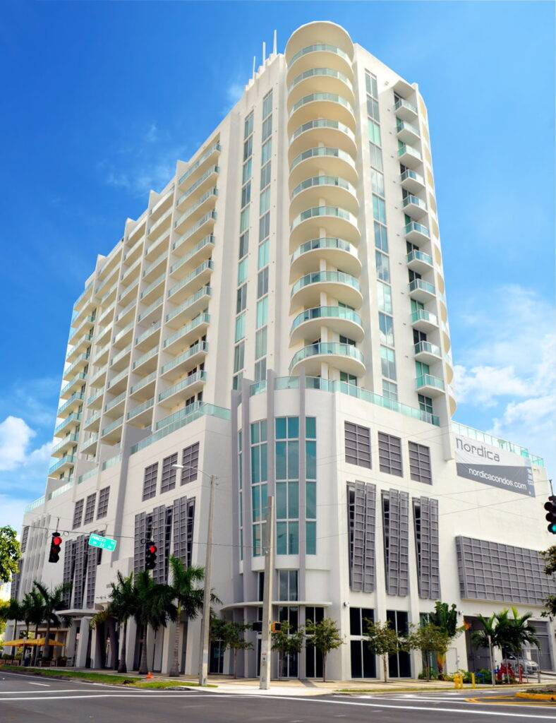 Modern high-rise building with unique architecture against a clear blue sky.