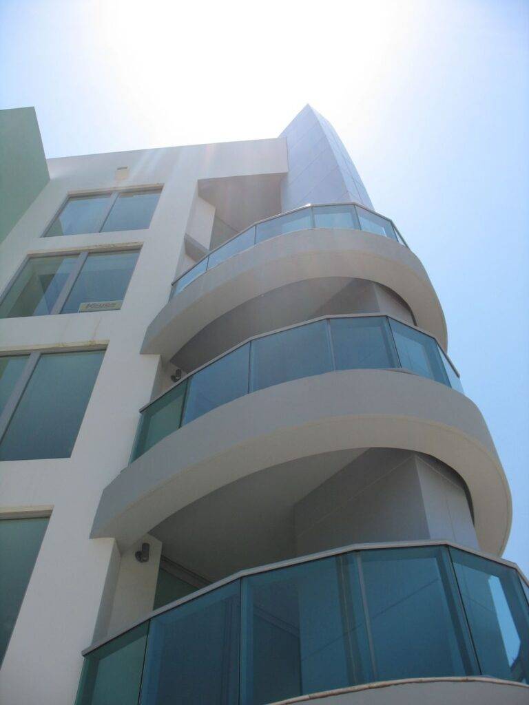Modern architectural design of South27 Lofts with curved balconies under a sunny sky.
