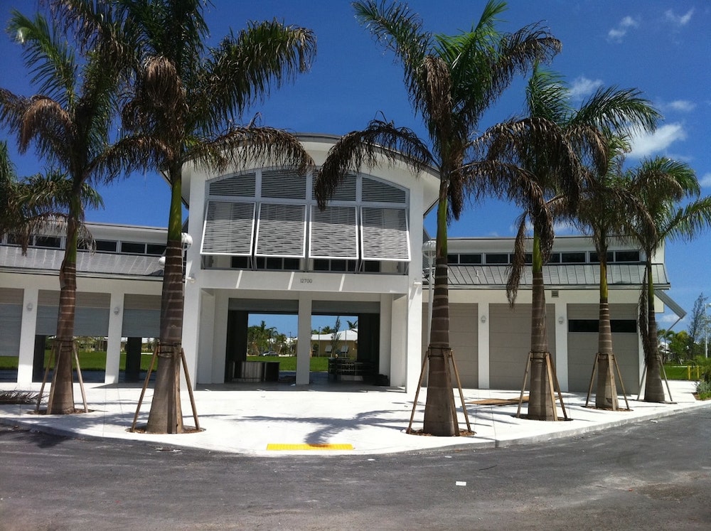 Modern community center surrounded by palm trees on a sunny day.