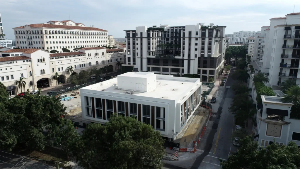 Aerial view of modern urban architecture surrounded by greenery, showcasing a blend of classic and contemporary building designs.