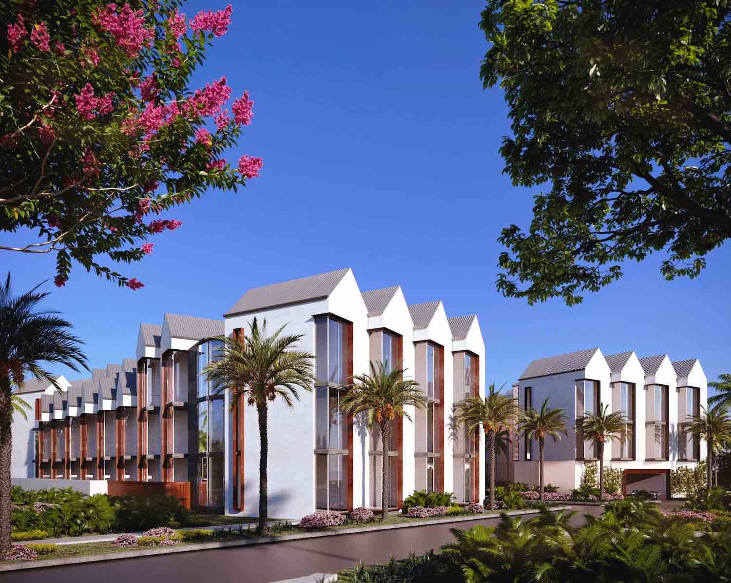 Modern architectural complex surrounded by palm trees and vibrant greenery under a clear blue sky.
