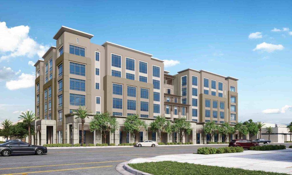 Modern five-story apartment building with glass windows and lush landscaping.