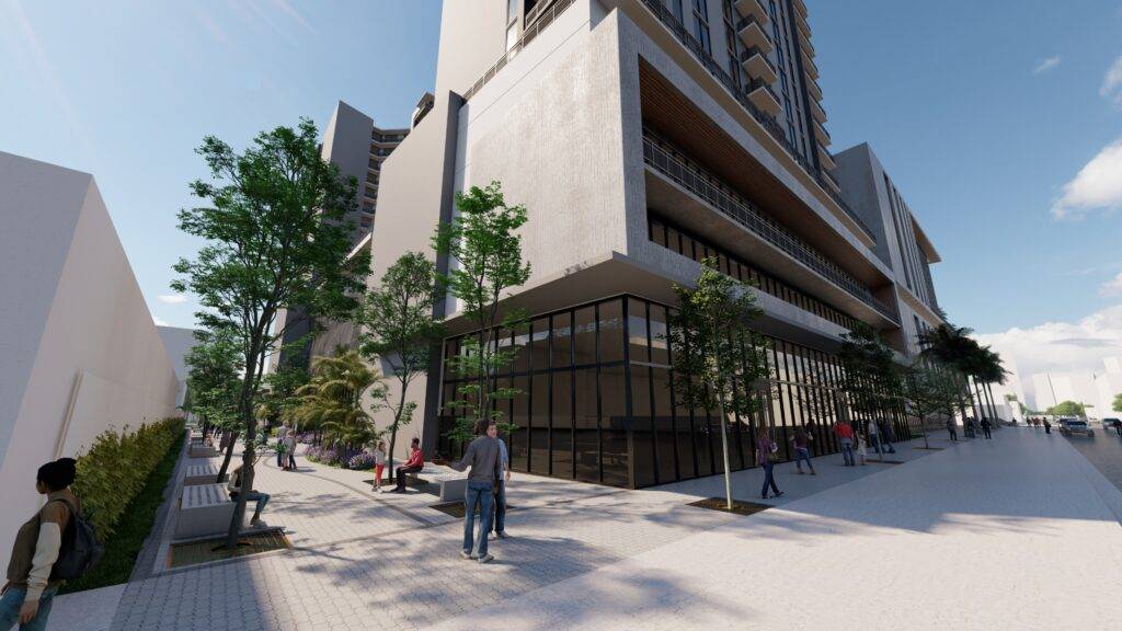 Modern city building with glass facade and pedestrians on a sunny day.