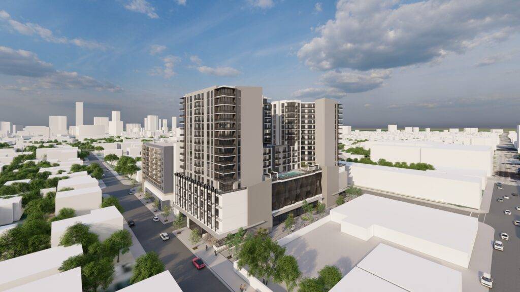 Modern urban development with tall buildings against a blue sky.