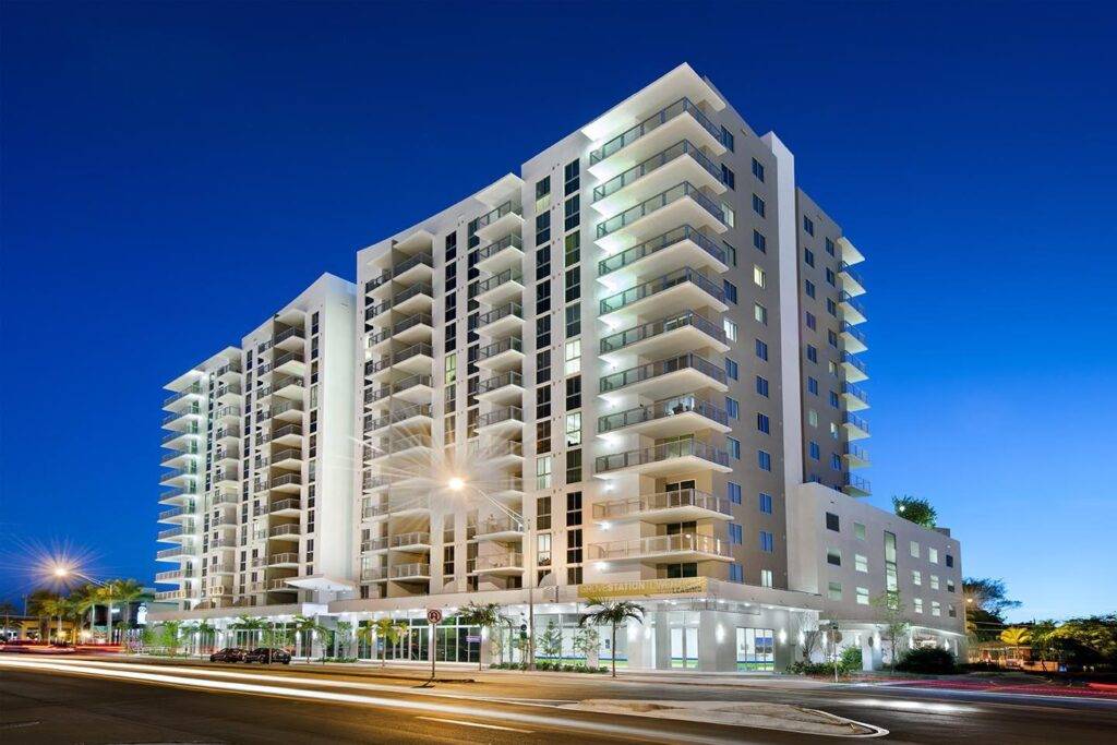 Modern high-rise building illuminated at dusk.
