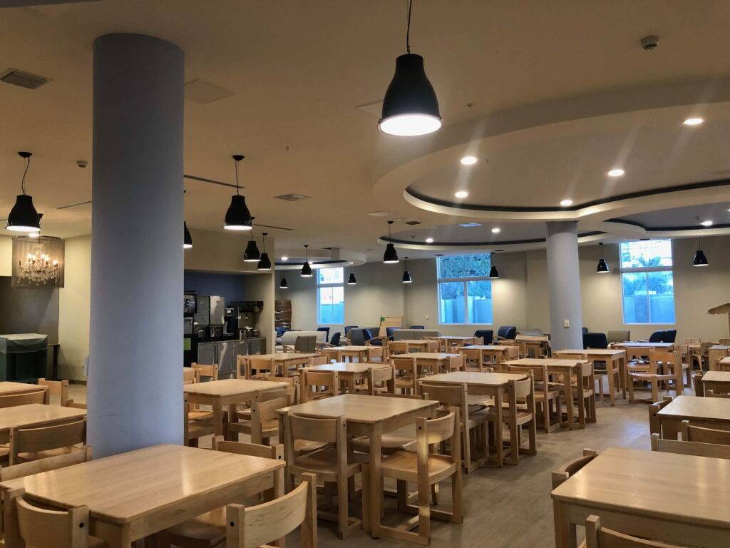 Spacious dining area with wooden tables and modern lighting.