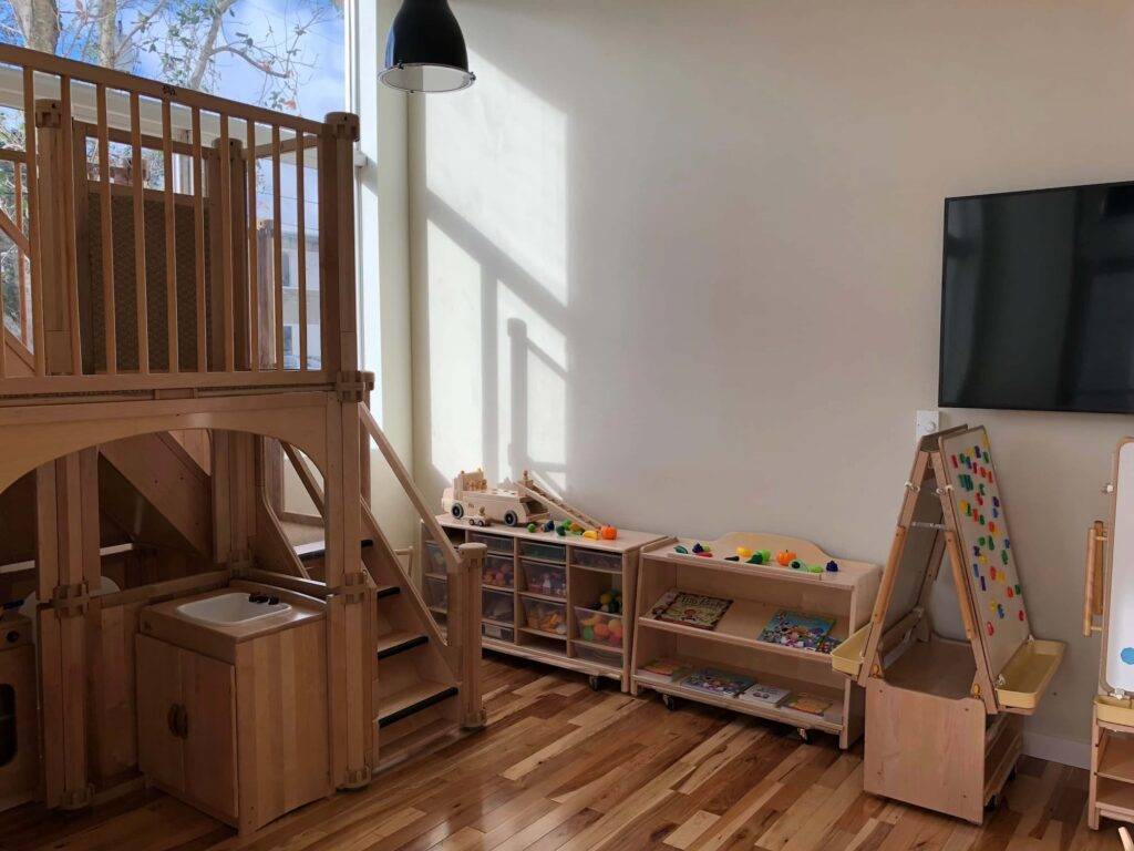 Cozy children's playroom with wooden loft, educational toys, and bright natural light.