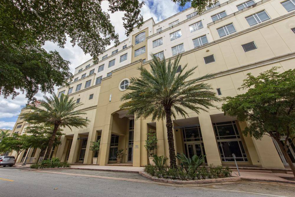 Elegant cream building with palm trees on a sunny day