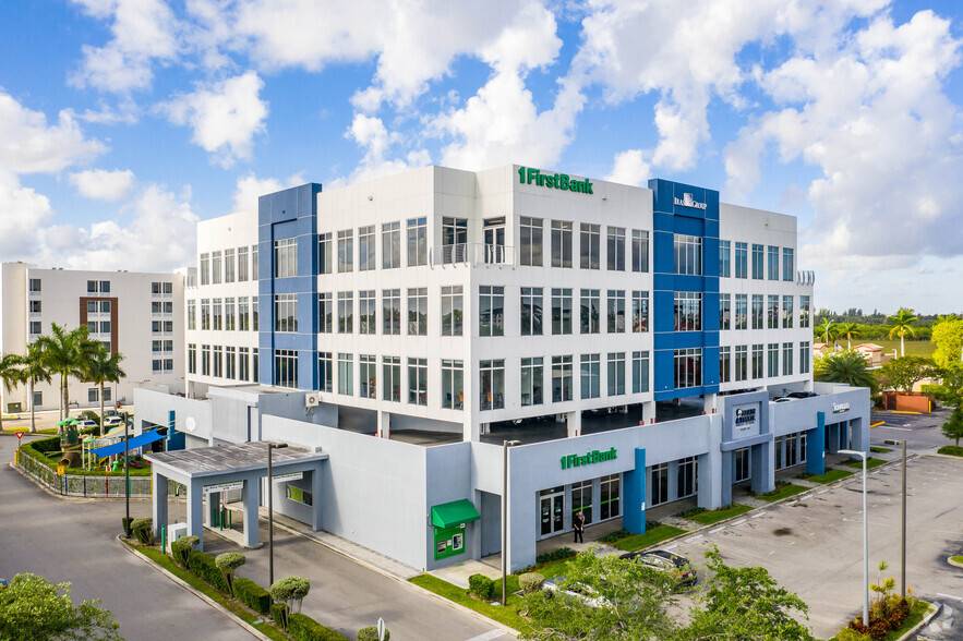 Modern office building with white and blue facade under a bright blue sky.
