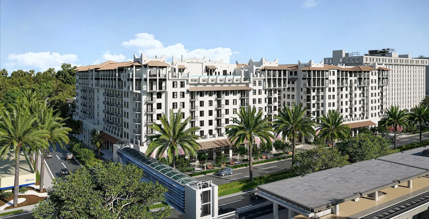 Elegant multi-story building surrounded by palm trees under a bright blue sky.
