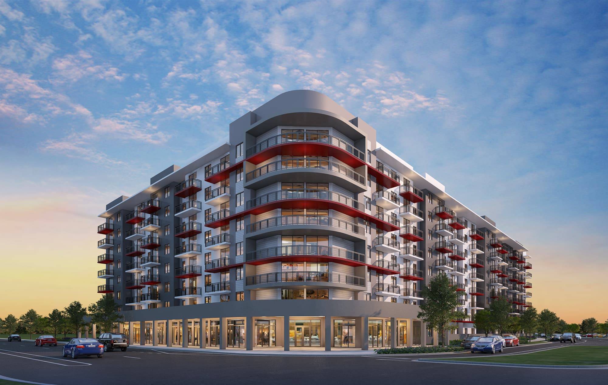 Modern multi-story building with red balconies under a vibrant sunset sky