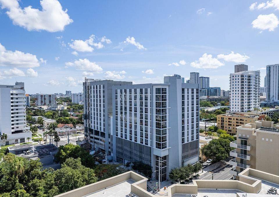 Aerial view of modern cityscape with tall buildings under a blue sky.