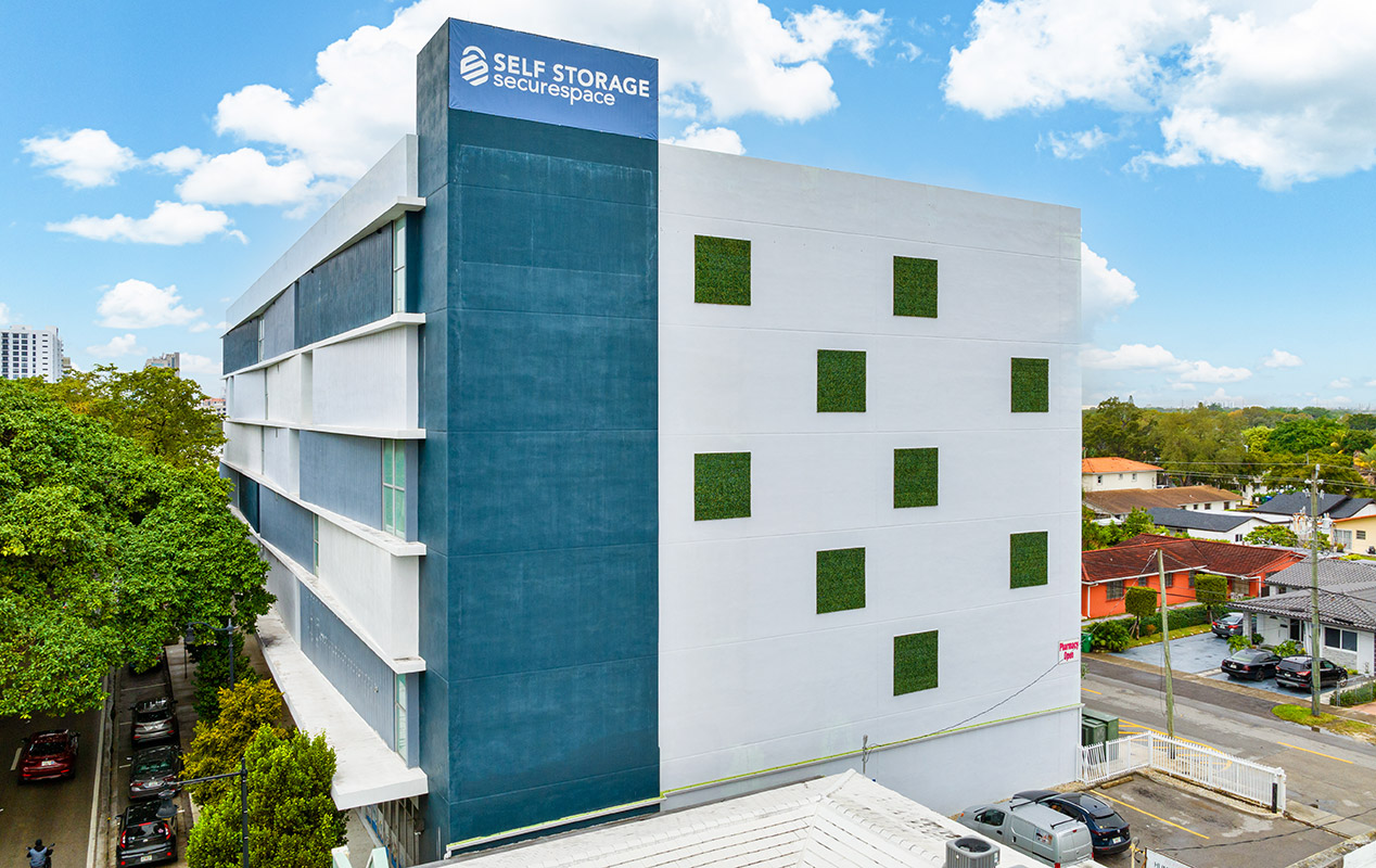 Modern self-storage building with blue and white facade in urban setting.