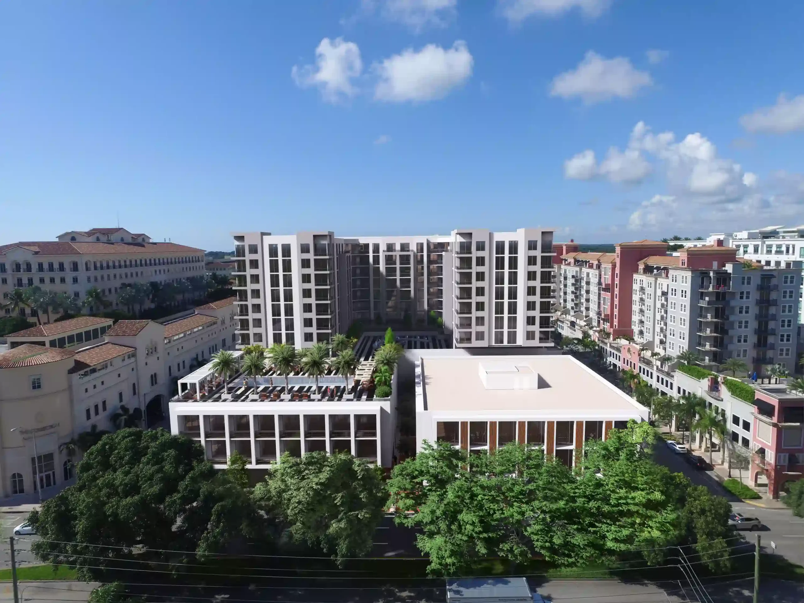 A modern urban landscape with high-rise buildings and lush greenery under a bright blue sky.