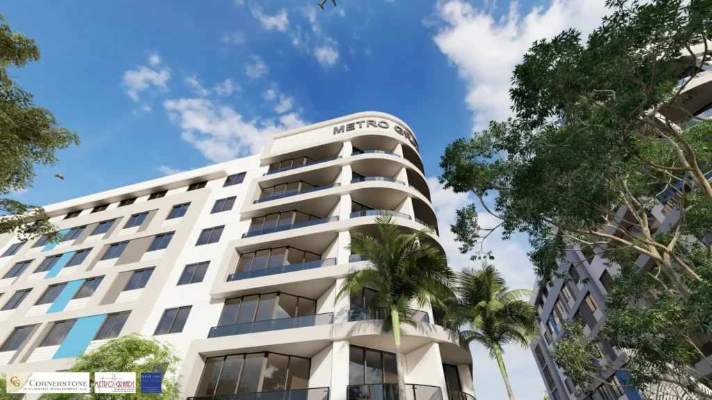 Modern high-rise building Metro Grande with lush trees and blue sky.