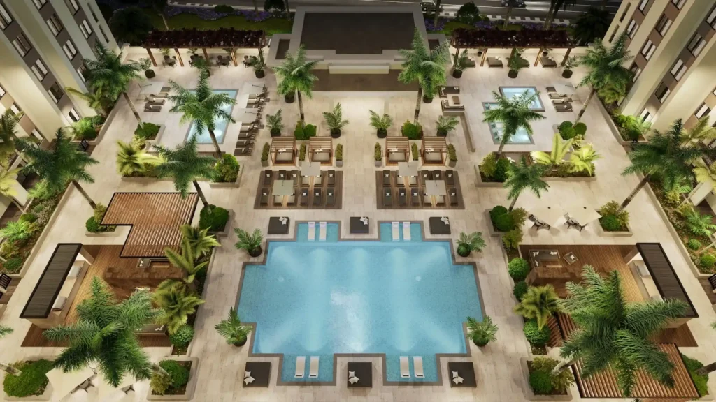 Aerial view of a luxurious hotel courtyard with multiple pools, palm trees, loungers, and seating areas.