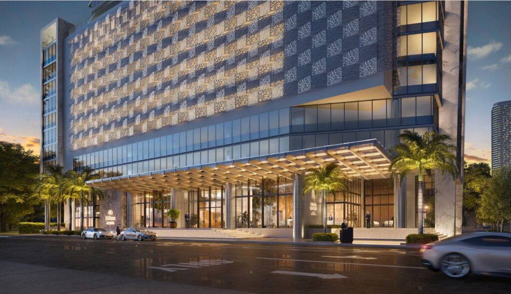 Okan Tower in Miami at dusk with sleek modern architecture and palm trees lining the street.