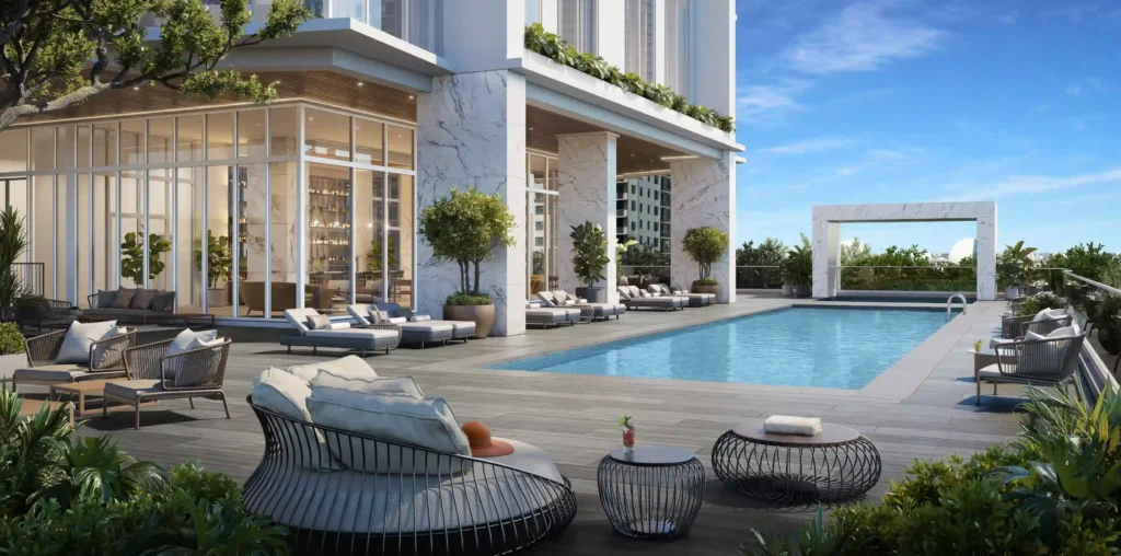 Luxurious outdoor pool area at a modern hotel with plush seating and vibrant greenery.