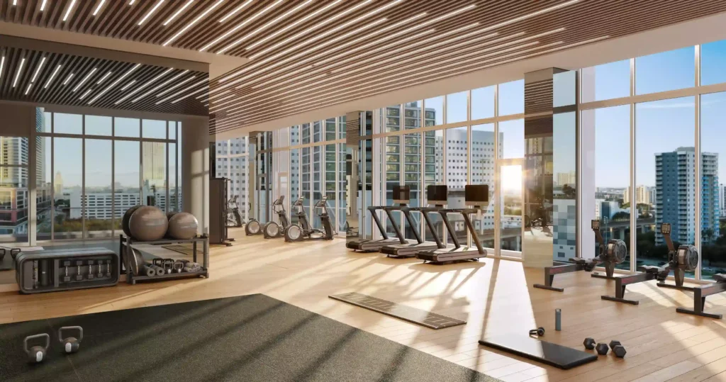 Luxurious gym at sunrise with modern equipment and city skyline views.
