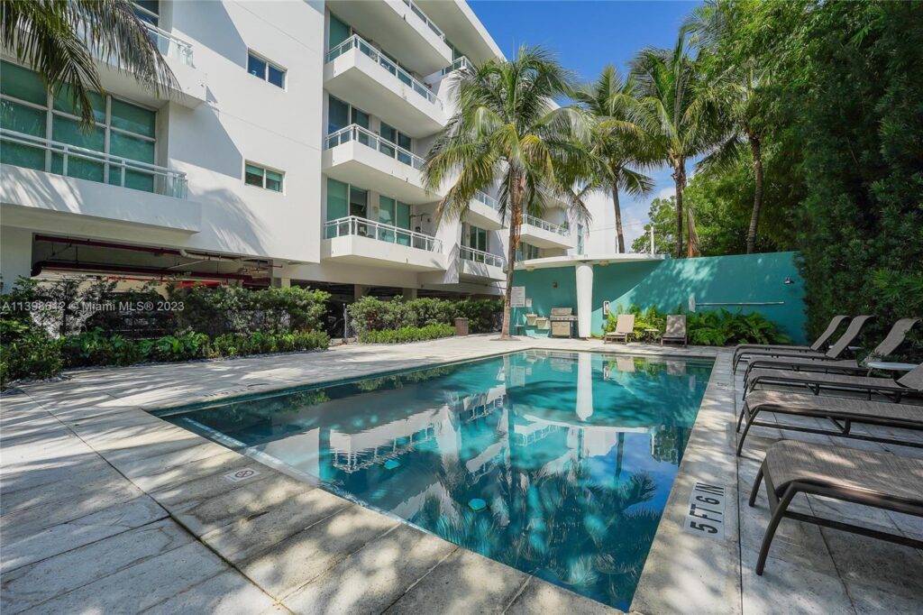 Modern apartment complex with pool and palm trees