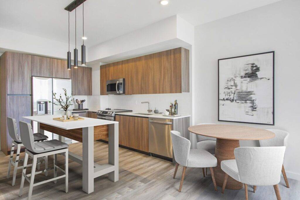 Modern kitchen and dining area with sleek wooden cabinets and minimalistic furniture.
