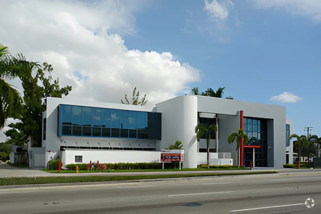 Modern commercial building with sleek design and large windows under a bright blue sky.
