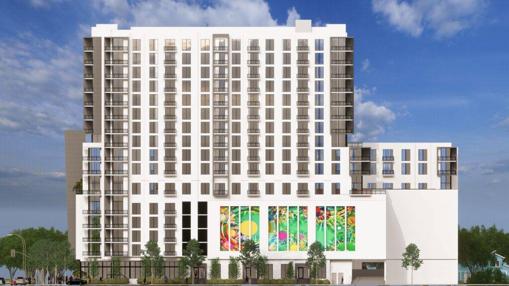 Modern high-rise building with colorful murals and clear blue sky.