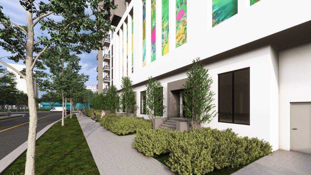 Modern urban streetscape with lush greenery and colorful murals on a building facade.