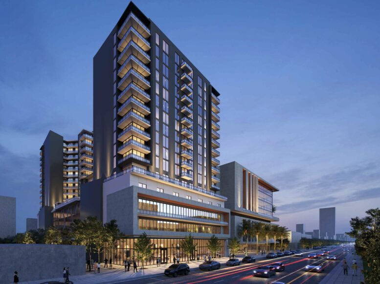 Modern high-rise building with illuminated windows against a twilight sky.