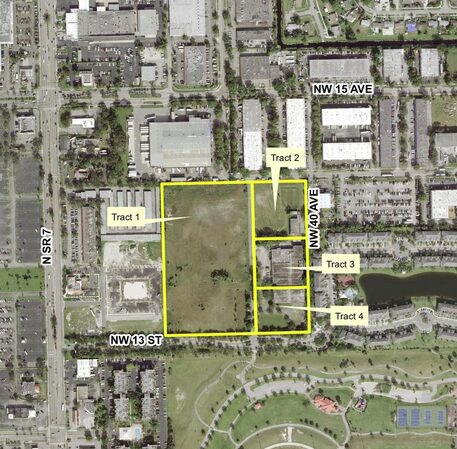 Aerial view of a city block highlighting multiple land tracts outlined in yellow with surrounding roads and buildings.