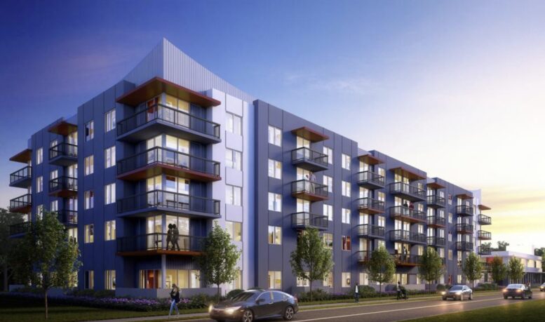 Modern apartment building with blue facade and balconies at sunset, surrounded by greenery.