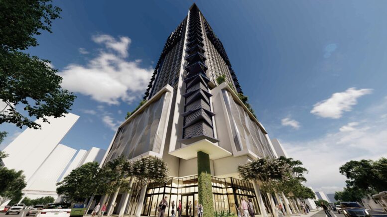Modern skyscraper with glass facade and greenery at the base, viewed from a low angle.