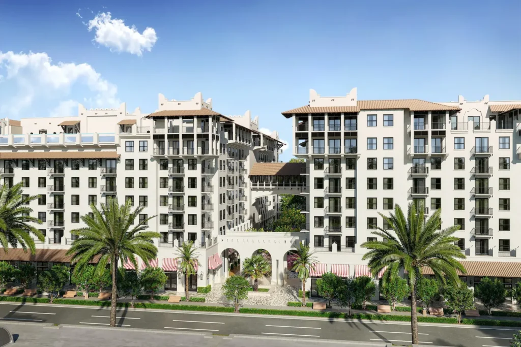 Elegant modern building with palm trees and a bright blue sky.