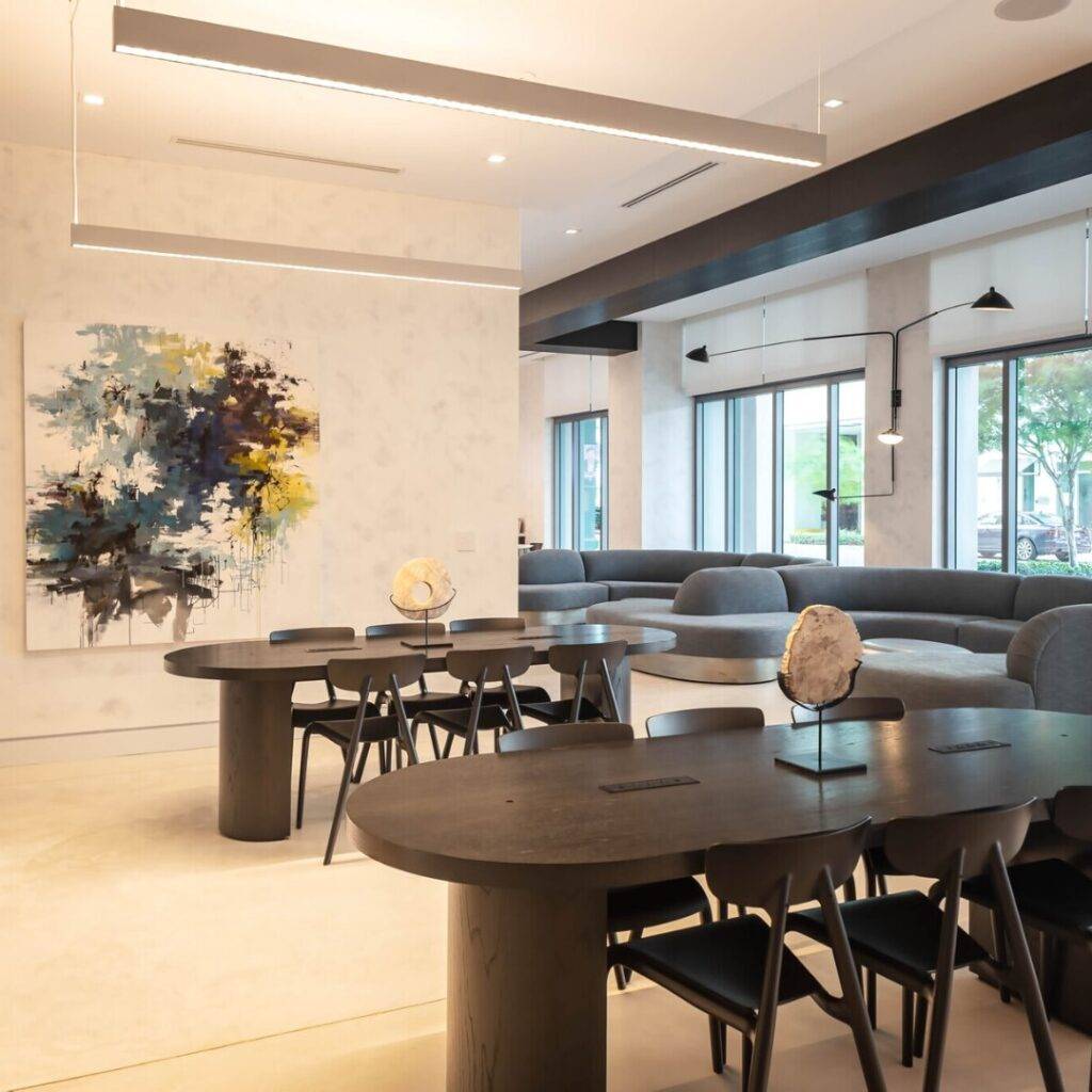 Modern dining area with sleek black tables, abstract artwork, and large windows