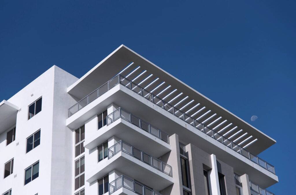 Modern white building against a clear blue sky with geometric design elements.