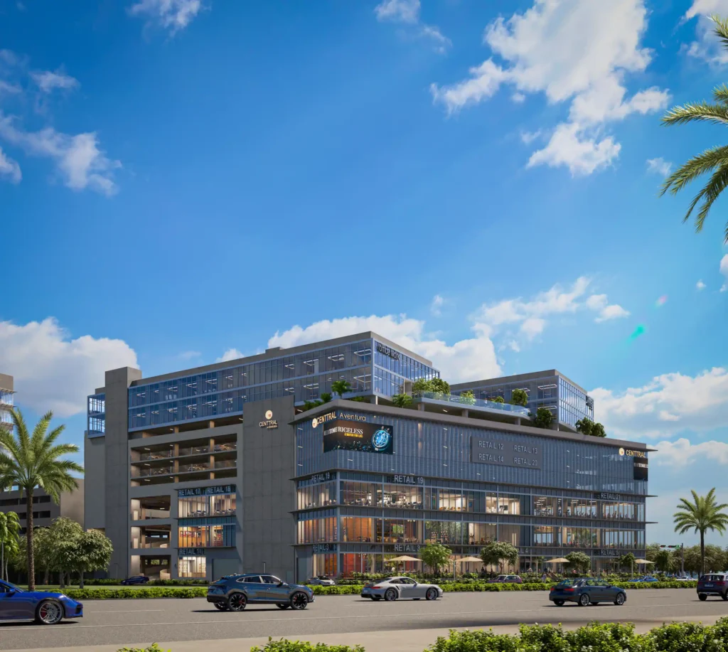 Modern urban building with glass facade, surrounded by palm trees under a blue sky.