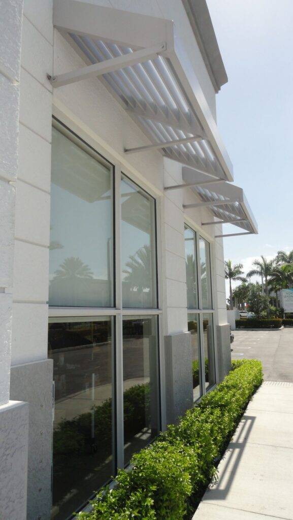 Modern building facade with large glass windows and stylish awnings.
