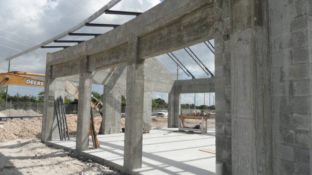 Construction site of modern concrete structure with exposed beams and clear sky