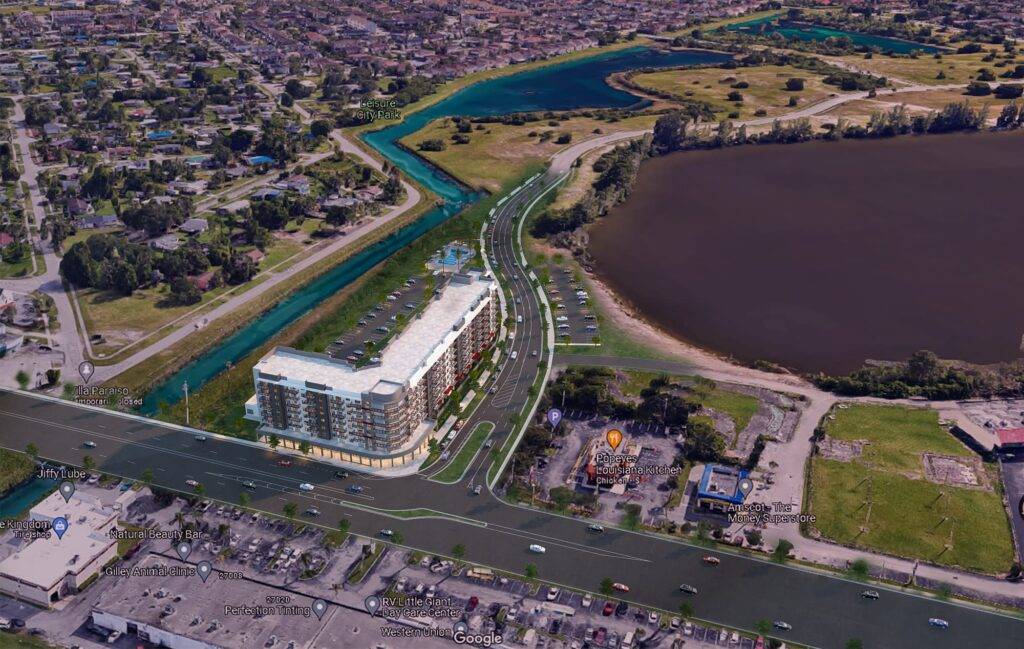 Aerial view of a modern waterfront development surrounded by lush greenery and a serene lake.