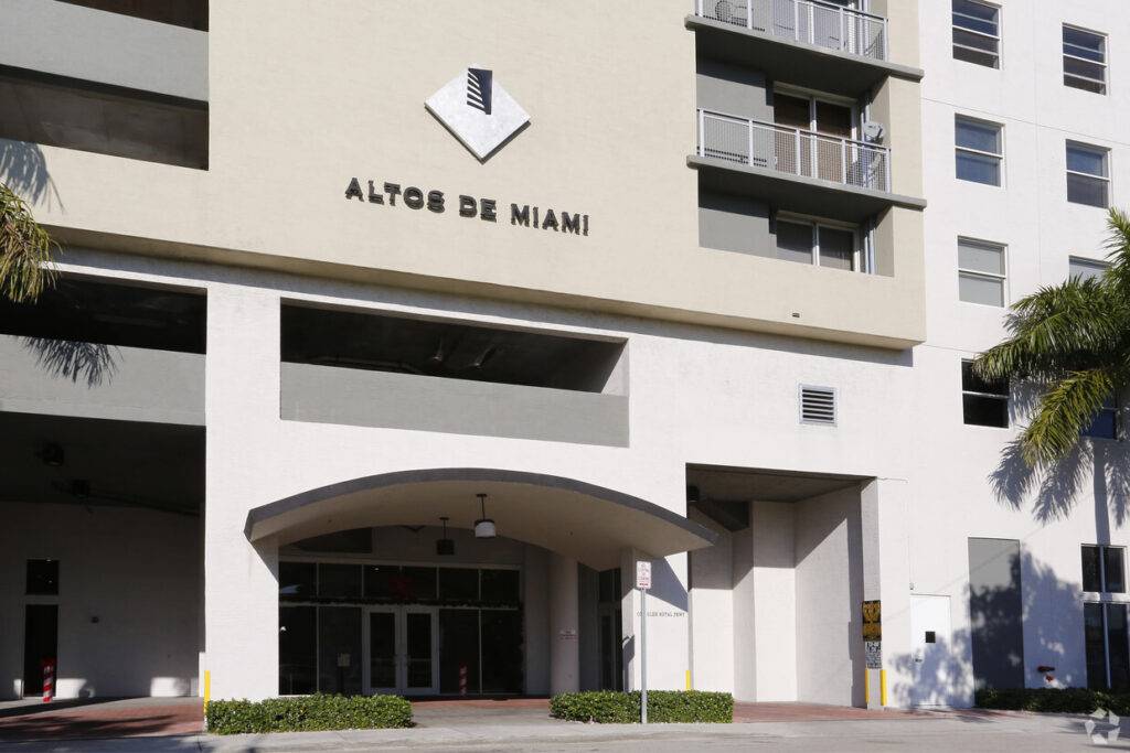 Altos de Miami building exterior featuring modern architecture and palm trees.