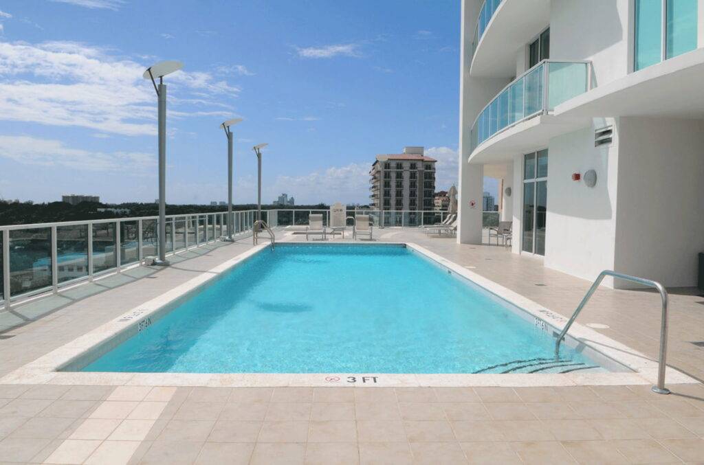 Rooftop pool with city skyline view and modern architecture.
