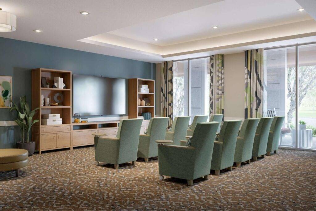 Cozy theater room with green armchairs and large screen in Coral Gables setting.