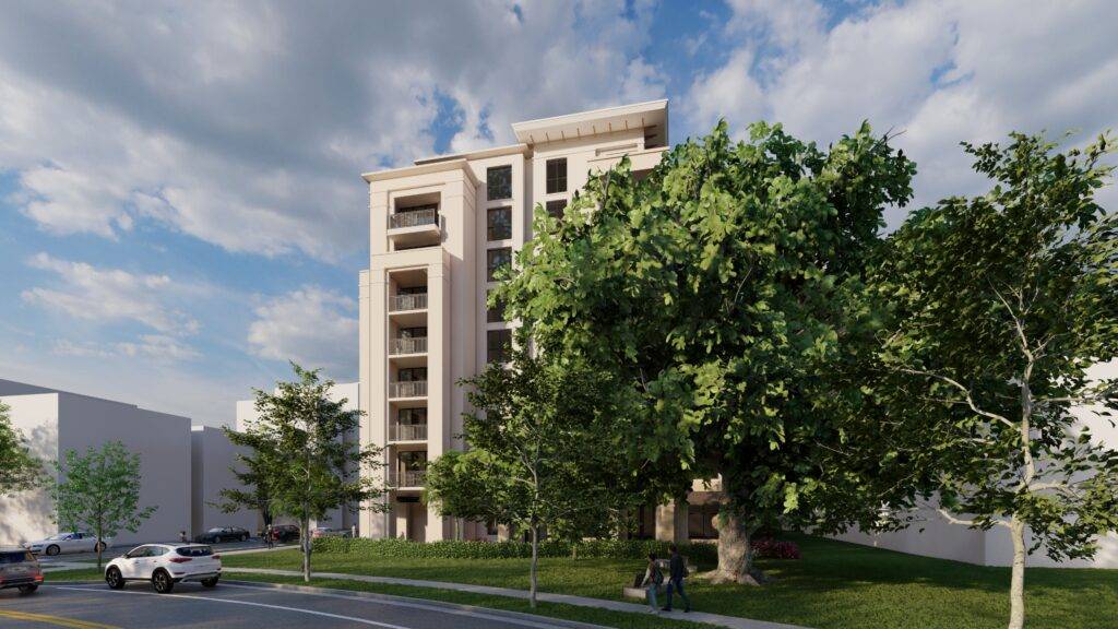 Modern residential building with a lush green tree in the foreground under a blue sky.