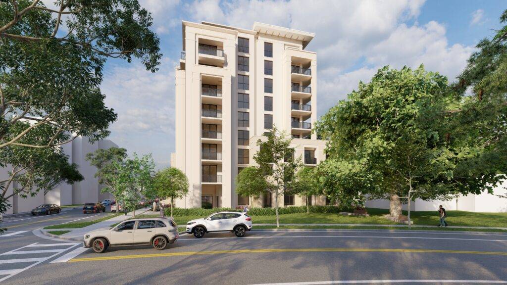 Modern apartment building surrounded by lush greenery and parked cars on a calm street.