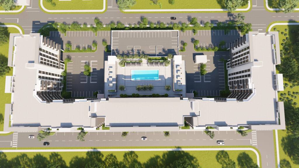 Aerial view of modern apartment complex with central pool and green landscaping.