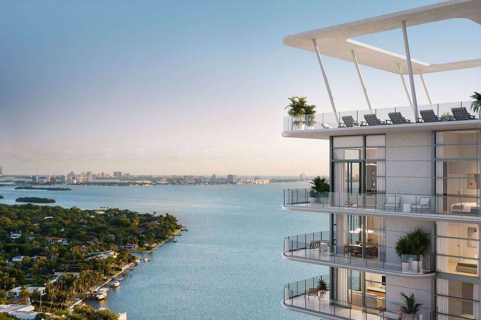 Modern Miami skyscraper overlooking the serene bay with lush greenery and bright blue skies.