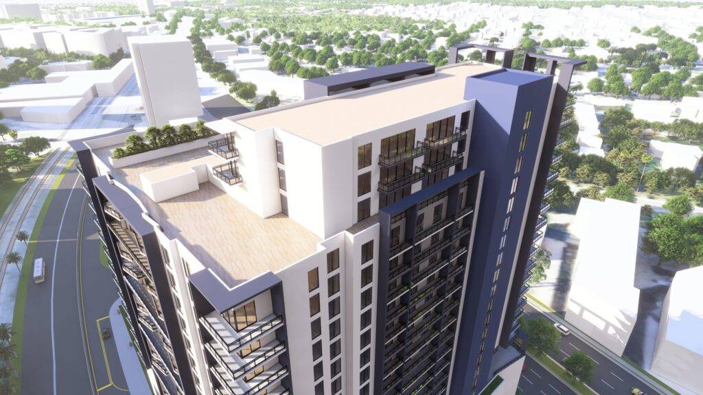 Aerial view of a modern high-rise building surrounded by a sprawling urban landscape on a sunny day.