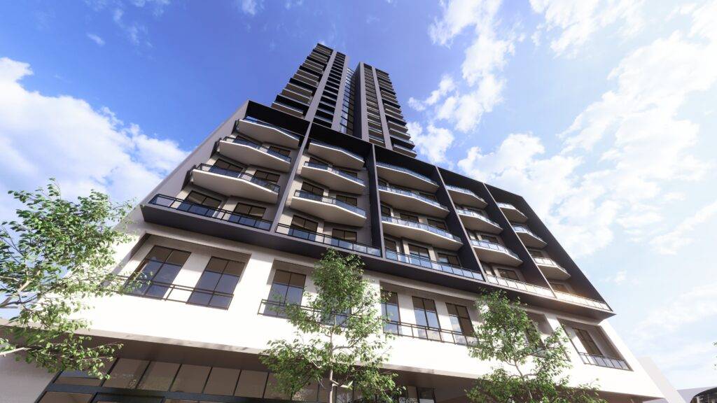 Modern high-rise building with balconies against a blue sky.