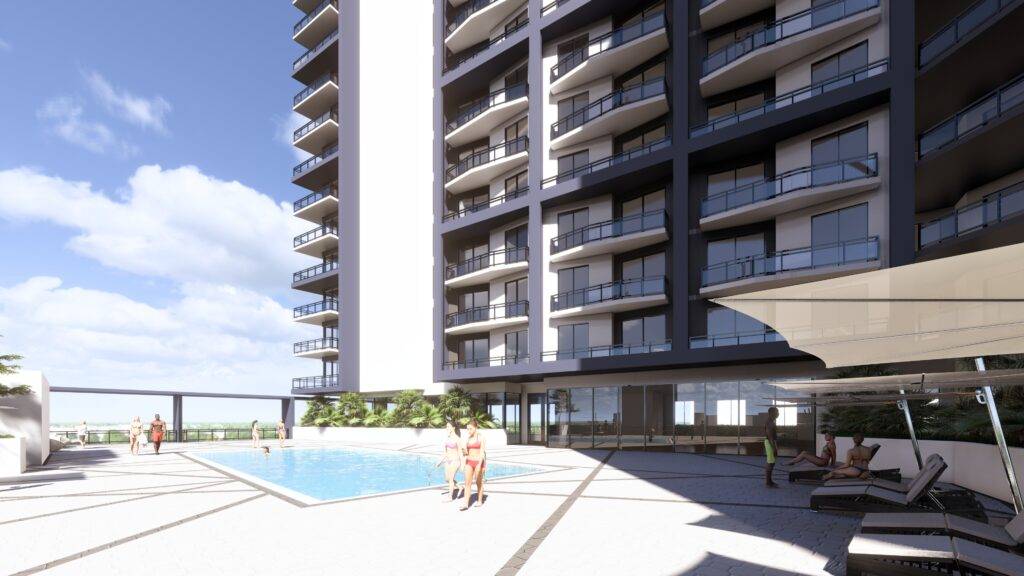 Modern apartment building with a pool and lounging area on a sunny day.