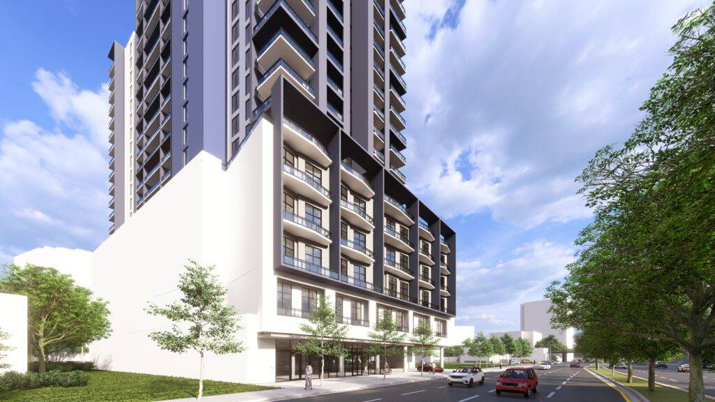 Modern high-rise apartment building on a sunny day with trees and cars in the foreground.